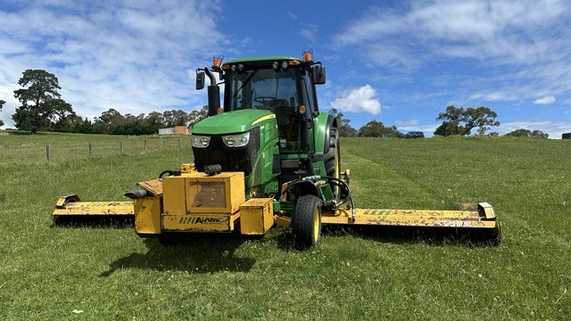 Front view of the John Deere with both Alamo side decks spread wide either side