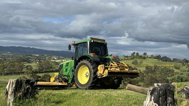 John Deere 140 hp tractor fitted with the Alamo Interstater 3-piece flail mowing system on a hilltop paddock